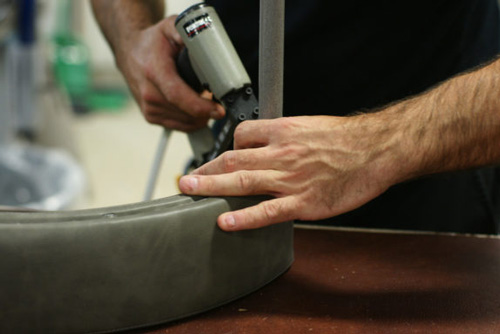 Upholsterer making a bar stool backrest.